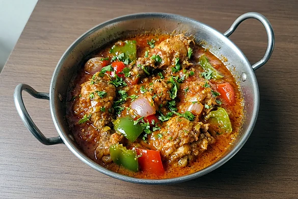 Chicken kadai curry with bell peppers in a steel kadai