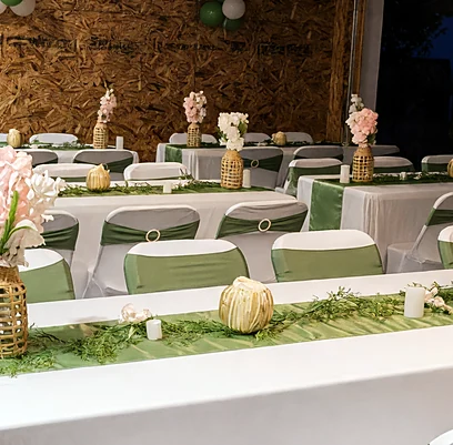 Event tables with green runners and flower centrepieces set by Ponnus Caters & Events